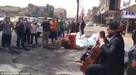 Chuyện “tiếng đàn át tiếng bom” ở Iraq gây xúc động - 3 Một
đám đông đang tập trung xung quanh cựu nhạc trưởng của Dàn nhạc Giao hưởng Quốc
gia Iraq.