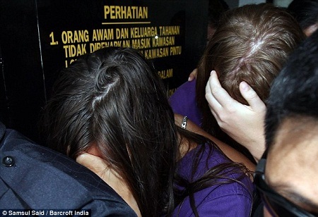 Cảnh sát đưa 4 du khách đã bị tạm giam tới tòa án thành phố
Kota Kinabalu.