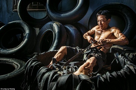 Nhiếp ảnh gia Việt Nam có nhiều ảnh xuất sắc tại giải ảnh quốc tế - 3 Người đàn ông đang tìm
cách tái chế những chiếc lốp cũ - Tác giả: Lý Hoàng Long.