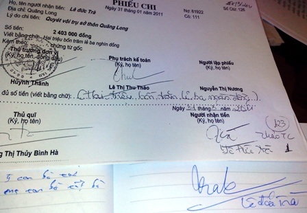 Một người dân đang so sánh chữ ký của mình với chữ ký trên phiếu chi