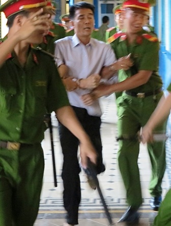 Bị cáo… đại náo phiên tòa - 1 Bị cáo Minh khiến các công an phải mướt mồ hôi mới đưa được ra xe về trại giam (Ảnh: K.N)