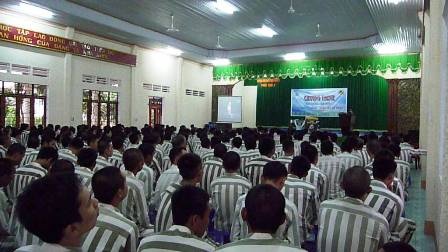 Các phạm nhân chăm chú theo dõi Nick diễn thuyết qua màn ảnh