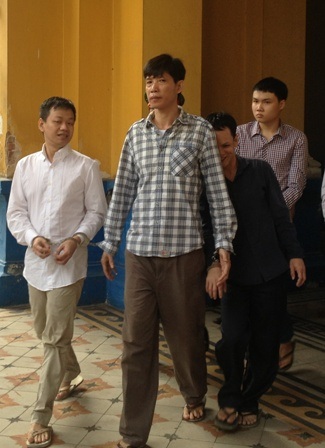 Mai Phước Hoàng mặc áo đen, nấp sau lưng