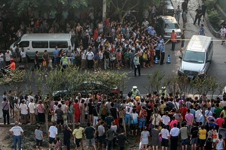 Trung Quốc: Tên cướp nguy hiểm sát hại 9 người đã bị bắn chết - 2 Người dân đứng kín hai bên đường xem xác Zhou bị đưa đi.