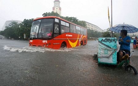 Thủ đô Philippines hoá “công viên nước” vì mưa lũ - 3 Xe buýt di chuyển trên một con phố ngập nước của thủ đô Philippines.