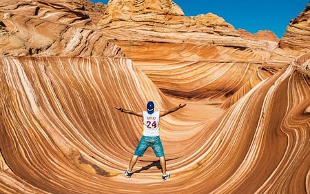 Một người đàn ông đứng giữa vùng sa sạch trên sa mạc Arizona, Mỹ.