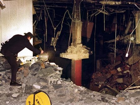 Một cảnh sát đang nhìn vào một hố sâu sau vụ đánh bom Trung tâm thương mại thế giới.