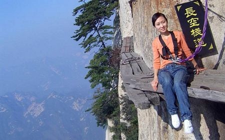 Thót tim cung đường chênh vênh trên vách đá - 8 Một du khách ngồi trên con đường siêu nhỏ để chụp ảnh kỷ niệm.