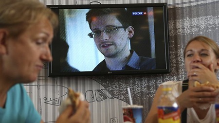 Snowden sống ra sao ở khu quá cảnh sân bay? - 1 Hành khách chờ tại sân bay Sheremetyevo trong lúc truyền hình Nga phát tin về Snowden.