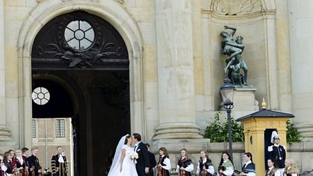 Chú rể vẫy tay chào mọi người sau khi bước ra từ nhà thờ.