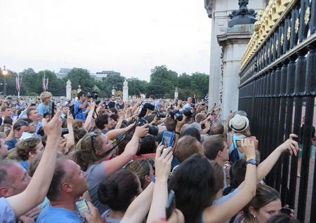 Mọi người chen chân bên ngoài cung điện Buckingham để cố gắng nhìn tận mắt thông báo của hoàng gia.