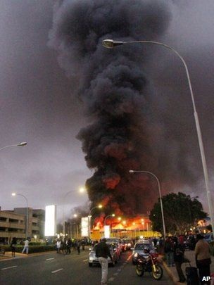 Cháy dữ dội tại sân bay quốc tế ở thủ đô của Kenya - 4 Người dân đứng quan sát vụ hỏa hoạn từ xa, trong khi xe cứu hỏa đang phun nước vào đám cháy.