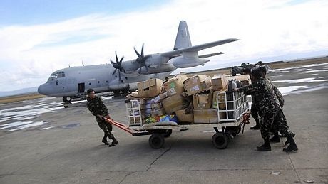 Các binh sĩ Mỹ đẩy một chiếc xe chở hàng cứu trợ được máy bay vận tải Mỹ đưa tới.