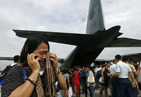 Binh sĩ Philippines phân phát từng miếng cam cho những người đang đứng chờ để lên máy bay vận tải.
