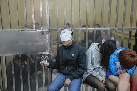 Trung Quốc: Tranh cãi chuyện cảnh sát dùng băng dính quấn đầu nghi phạm - 3 Một số nghi phạm bị quấn đầu và mặt bằng băng dính và báo.