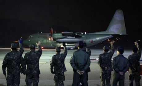 Các binh sĩ Mỹ đẩy một chiếc xe chở hàng cứu trợ được máy bay vận tải Mỹ đưa tới.