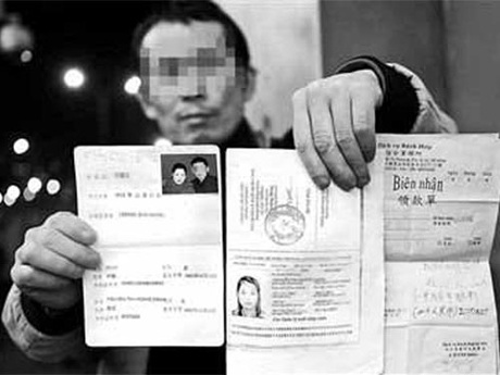 Một người đàn ông Trung Quốc cầm ảnh cô vợ Việt đã bỏ trốn. Ảnh: Mạng Tân An