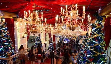 Du khách đi giữa các cây thông Nodel và dưới ánh đèn màu rực rỡ tại Hồng Kông, Trung Quốc.