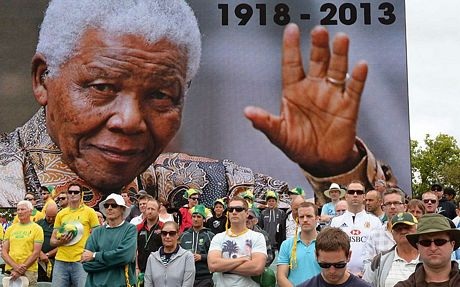 Một phụ nữ cúi đầu trước một bức tượng Nelson Mandela khác ở London.