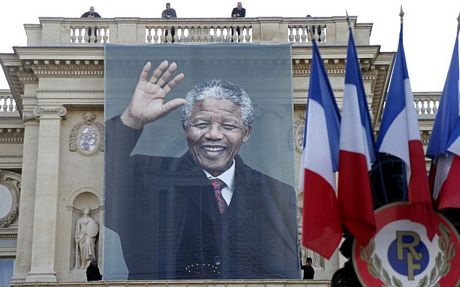Một phụ nữ cúi đầu trước một bức tượng Nelson Mandela khác ở London.