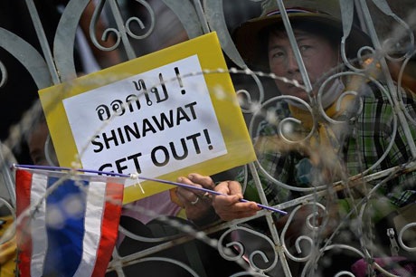 Người biểu tình Thái xuống đường ủng hộ “đóng cửa” Bangkok - 1 Một người biểu tình cầm tấm biển kêu gọi lật đổ gia tộc Shinawat tại Bangkok ngày 9/12/2013.