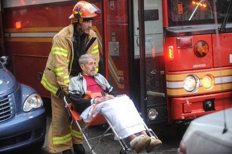 Một người đàn ông nhiều tuổi được sơ tán khỏi tòa nhà.