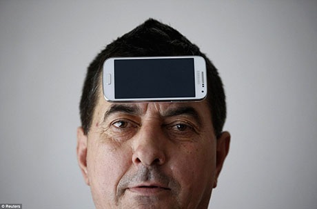 Chiếc điện thoại dính chặt trên trán ông.