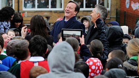 Thủ tướng Anh David Cameron cười với các học sinh trong chuyến thăm một ngôi trường ở Birmingham.