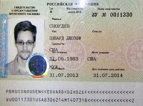 Tình báo Nga dụ Snowden tới Moskva như thế nào? - 1 Edward Snowden với tấm hộ chiếu tị nạn tạm thời do Nga cấp. Ảnh: Reuters