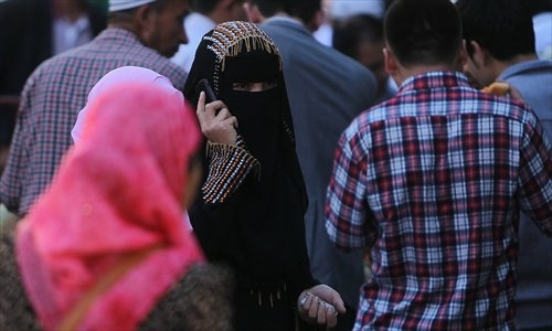 Một số phụ nữ Duy Ngô Nhĩ bắt đầu quen với việc đội khăn trùm đầu.