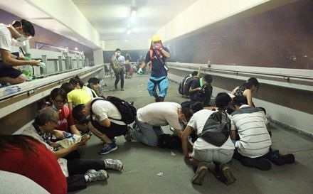 Người biểu tình cúi xuống đường để tránh hơi cay của cảnh sát.