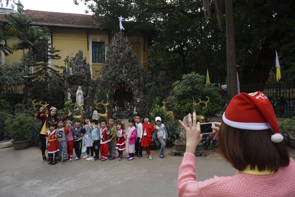 Hà Nội: Nhà thờ cổ kính trang hoàng đón Giáng sinh - 7
Các em nhỏ trong trang phục ông già Noel chụp ảnh lưu niệm trước hang đá - nơi chúa giáng sinh - tại sân nhà thờ Cửa Bắc.
