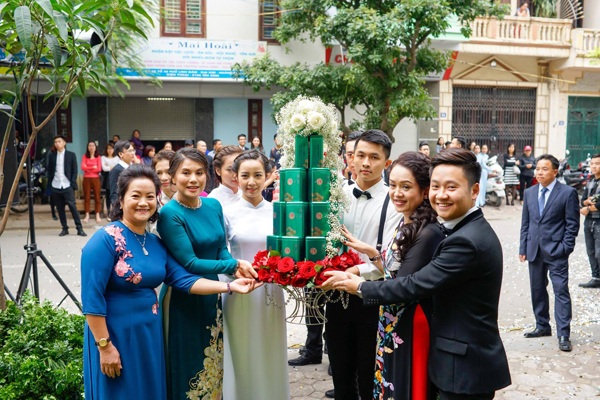 "Hot girl thời tiết" Mai Ngọc đằm thắm trong lễ ăn hỏi - 6 Nhà trai xuất hiện lúc 13 giờ chiều. Chồng Mai Ngọc diện bộ vest đen bảnh bao với phần cổ áo bằng nhung, đồng điệu với áo dài của nữ MC.