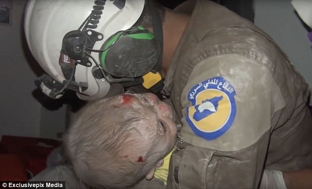 Lính cứu hộ Syria bật khóc nức nở khi cứu bé gái sau cuộc không kích - 1 Người lính cứu hộ bật khóc khi giải cứu thành công bé gái khỏi đống đổ nát ở Syria (Ảnh: Exclusivepix Media)