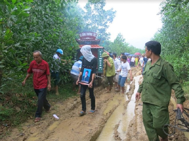 
Gia đình, xóm làng tiễn đưa anh Thưởng trên con đường lầy lội mùa lũ.
