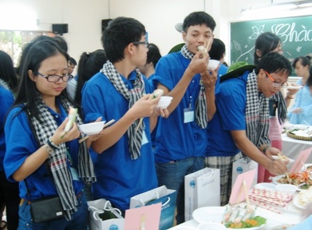 Thanh niên kiều bào hướng về cội nguồn - 2 Các bạn trẻ kiều bào thích thú với các món ăn Việt Nam.