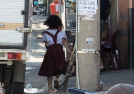 Cô học trò lớp 2 len mình giữa chiếc xe tải để về nhà. 