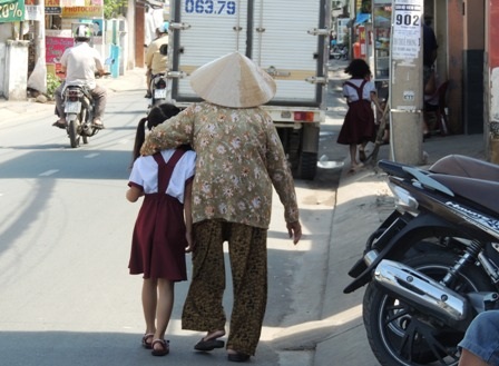 Cô học trò lớp 2 len mình giữa chiếc xe tải để về nhà. 