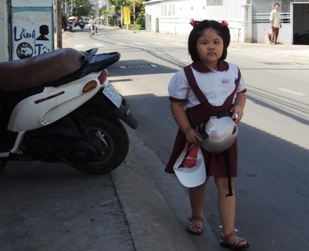 Cô học trò lớp 2 len mình giữa chiếc xe tải để về nhà. 