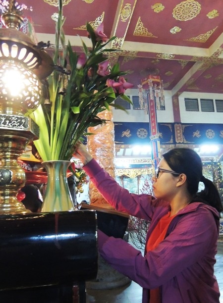 Bạn trẻ “trốn” lên chùa vào thời khắc giao thừa - 7 Một cô gái cắm cành lộc ở chùa Vĩnh Nghiêm.