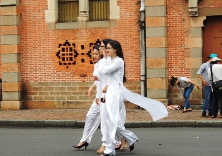 Tà áo dài trắng tung bay trên đường phố Sài Gòn. 