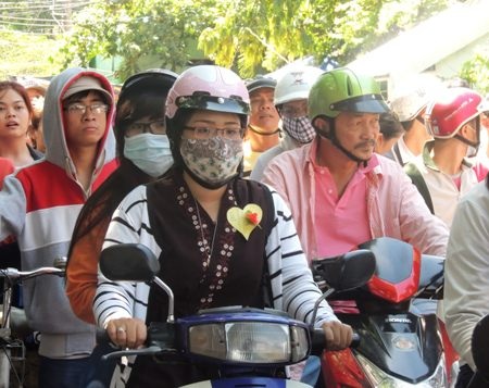 Những người dự lễ từ chùa đi ra cũng đành tắt máy xe đứng chờ đường lưu thông. 