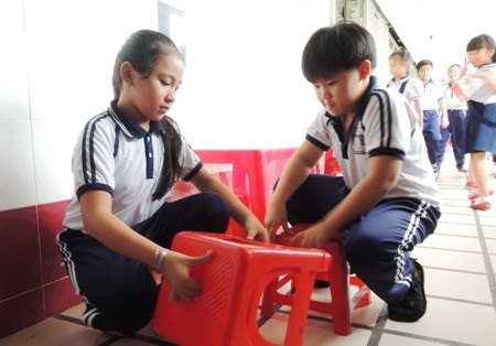 Một nhóm học sinh khác có nhiệm vụ dọn bàn ghế.