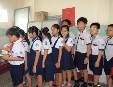 Học sinh xếp hàng ngay ngắn chờ để lấy thức ăn