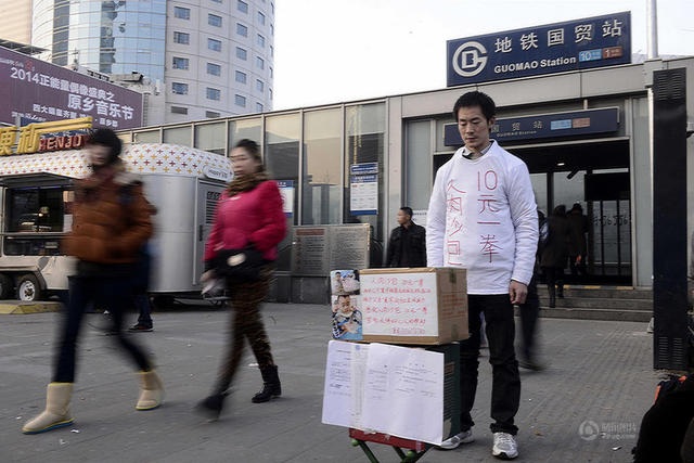 Mang thân chịu đấm mong kiếm tiền chữa bệnh cho con - 1 Xia đứng trên đường phố mời mọi người đấm mình để có tiền chữa bệnh cho con