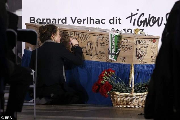 Tranh biếm họa phủ kín quan tài nạn nhân vụ khủng bố Charlie Hebdo - 4 Một vị khách đang viết những dòng chữ vĩnh biệt ông (Ảnh: