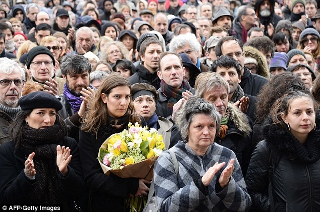 Tranh biếm họa phủ kín quan tài nạn nhân vụ khủng bố Charlie Hebdo - 5 Một vị khách đang viết những dòng chữ vĩnh biệt ông (Ảnh: