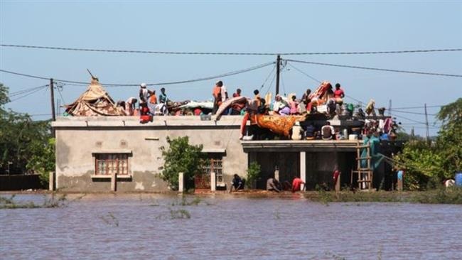 Việt Nam hỗ trợ nạn nhân lũ lụt tại Mozambique - 1 Người dân Mozambique trèo lên mái nhà để tránh lũ (Ảnh PressTV)