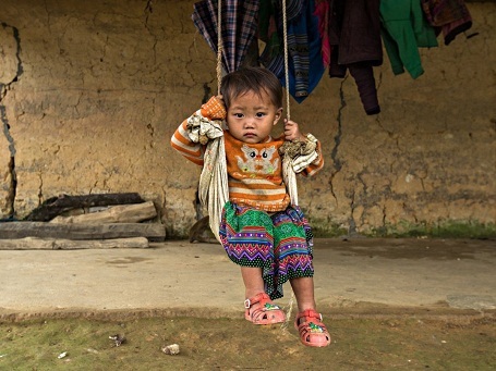Em bé người H’mông đang ở nhà một mình khi nhiếp ảnh gia Réhahn đi ngang qua nhà em và dừng lại chụp ảnh.