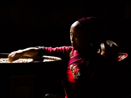 Bà mẹ vừa địu con vừa làm việc.